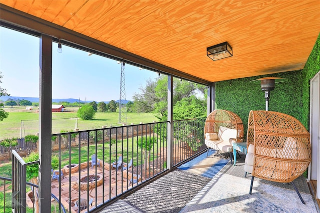 sunroom / solarium featuring wood ceiling and a rural view