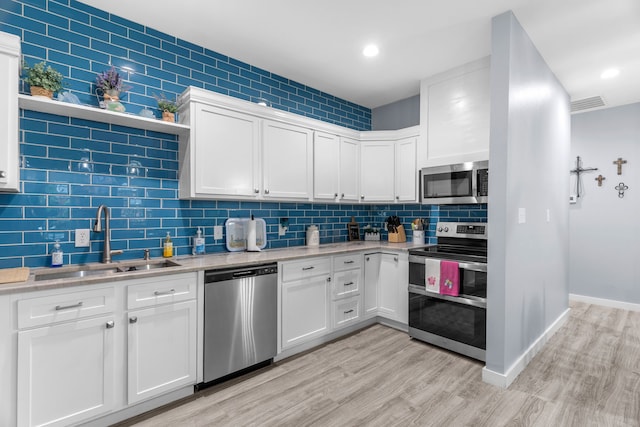 86593 N State Highway 289, Pottsboro, TX 75076 - kitchen featuring sink, white cabinets, decorative backsplash, light hardwood / wood-style floors, and stainless steel appliances