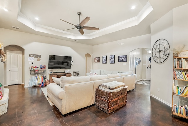 living room featuring ornamental molding, ceiling fan, and a tray ceiling