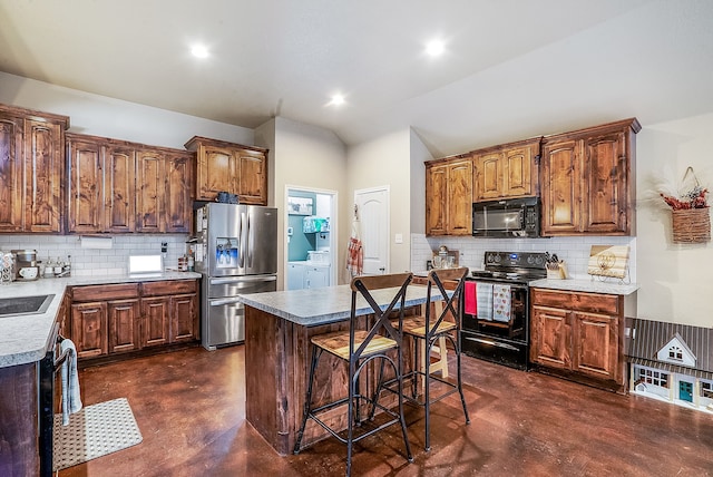 kitchen with tasteful backsplash, black appliances, washer and dryer, and a kitchen island