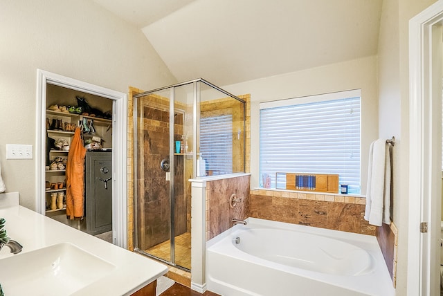 bathroom featuring vanity, shower with separate bathtub, vaulted ceiling, and a wealth of natural light