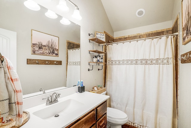 bathroom featuring vanity, lofted ceiling, a shower with shower curtain, and toilet