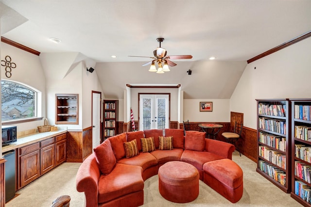 living room featuring a wealth of natural light, ornamental molding, light colored carpet, and wood walls