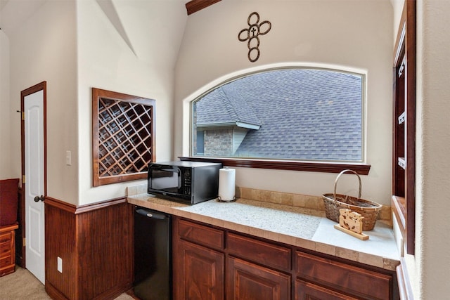 kitchen featuring fridge, wooden walls, and vaulted ceiling