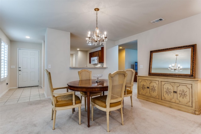 dining area featuring a notable chandelier and light colored carpet