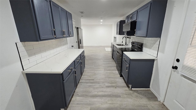 kitchen featuring light wood-type flooring, sink, black electric range, and backsplash