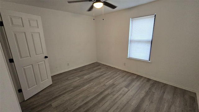 empty room with ceiling fan, dark hardwood / wood-style flooring, and a wealth of natural light