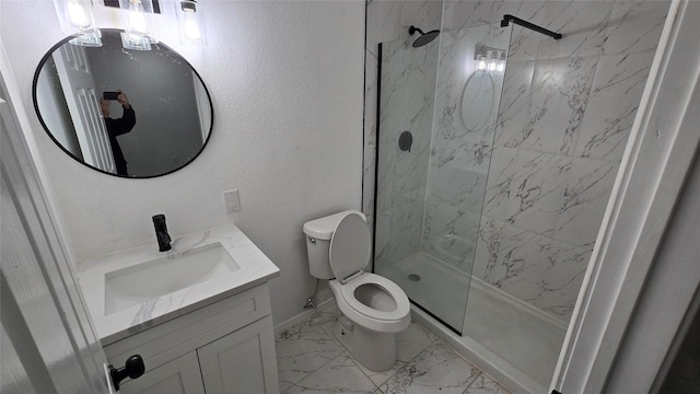 bathroom with vanity, a tile shower, and toilet