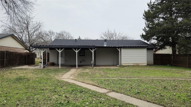 rear view of property with a patio and a lawn