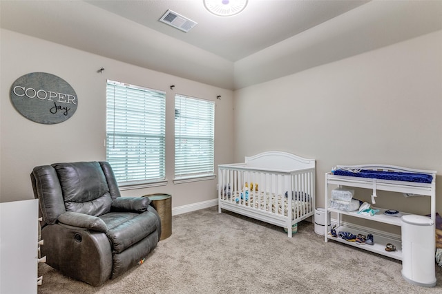 bedroom with carpet floors, a crib, and lofted ceiling