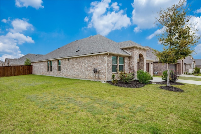 view of side of home with a yard