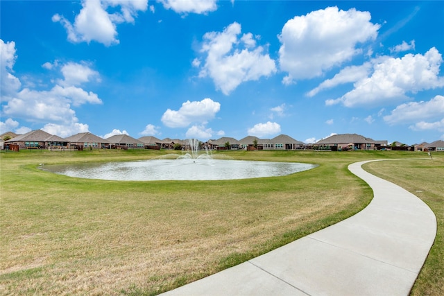 view of property's community with a yard and a water view