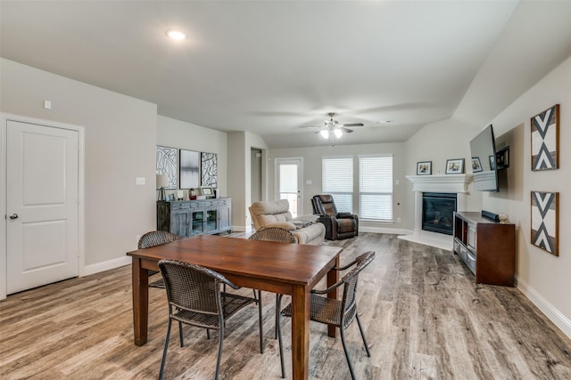 dining room with light hardwood / wood-style flooring, ceiling fan, and vaulted ceiling