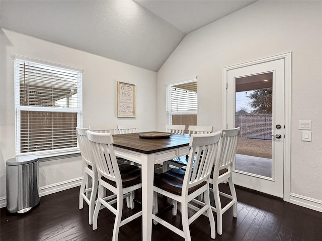 dining area featuring vaulted ceiling and dark wood-type flooring