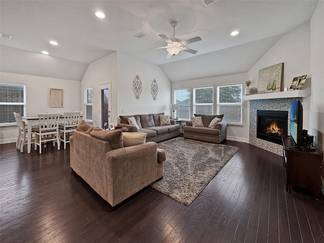 living room with lofted ceiling, a wealth of natural light, and dark hardwood / wood-style flooring