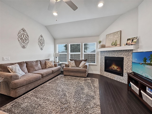 living room featuring dark hardwood / wood-style flooring, a fireplace, lofted ceiling, and ceiling fan