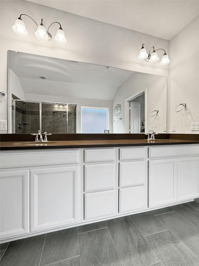 bathroom featuring tile patterned flooring, vanity, vaulted ceiling, and an enclosed shower