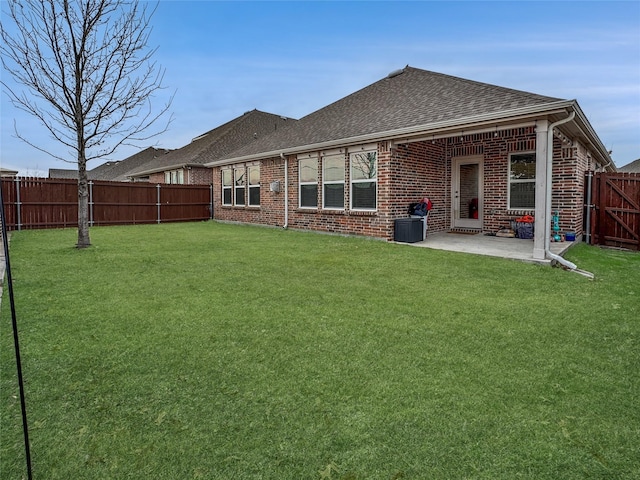 back of property with a yard and a patio area