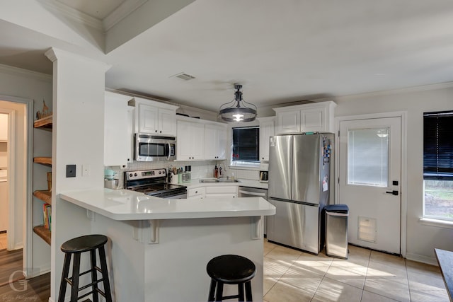 kitchen featuring stainless steel appliances, a breakfast bar, and white cabinets