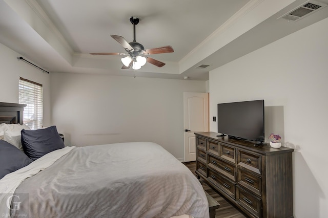 bedroom with a raised ceiling, dark hardwood / wood-style flooring, and ceiling fan