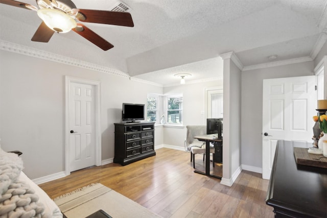 living room with hardwood / wood-style flooring, ornamental molding, and a textured ceiling