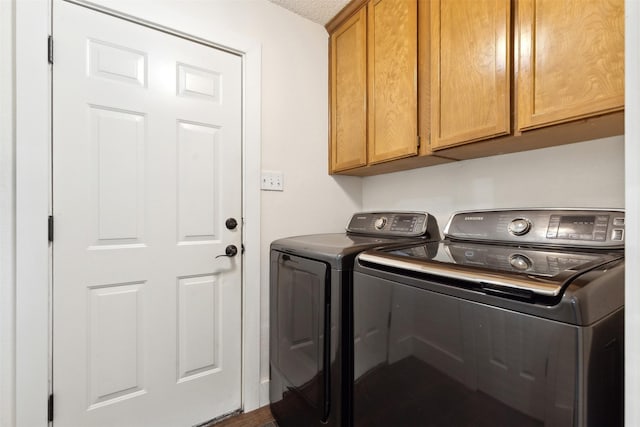 clothes washing area with cabinets, washing machine and dryer, and a textured ceiling