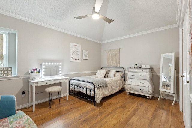 bedroom featuring hardwood / wood-style flooring, ornamental molding, lofted ceiling, and ceiling fan