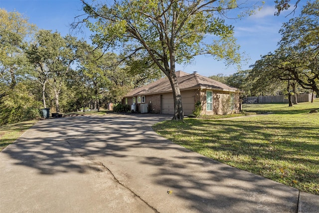 view of front of property featuring a garage, a front yard, and central air condition unit