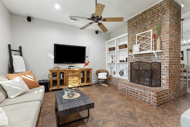 living room featuring ceiling fan, a fireplace, and a textured ceiling