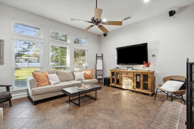 living room featuring ceiling fan, a healthy amount of sunlight, and a textured ceiling