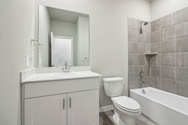 full bathroom with tiled shower / bath, vanity, and toilet