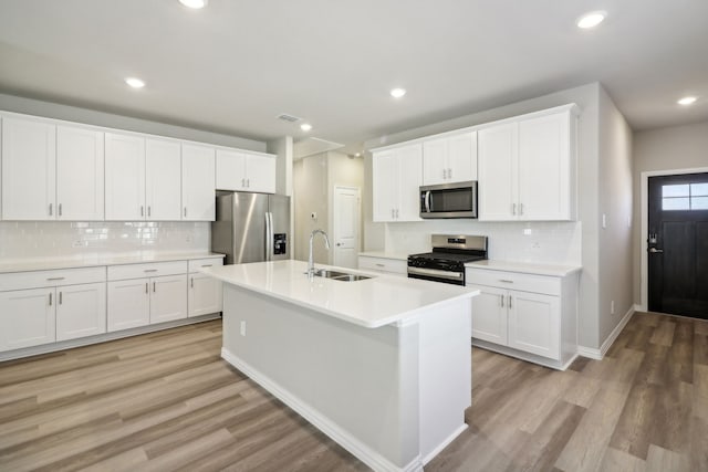 kitchen with stainless steel appliances, sink, and white cabinets