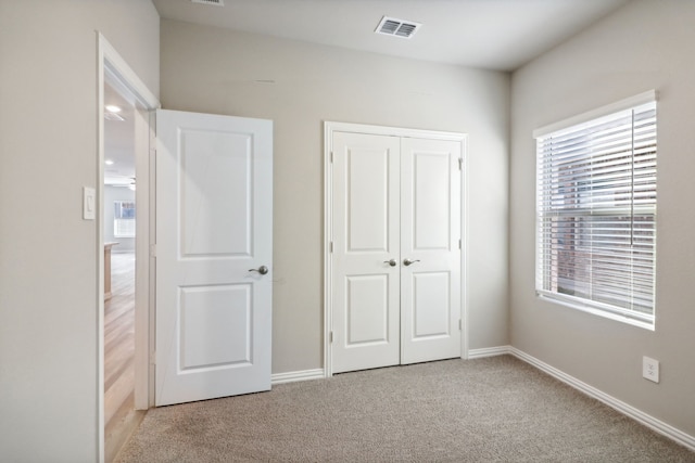 unfurnished bedroom featuring a closet and light carpet