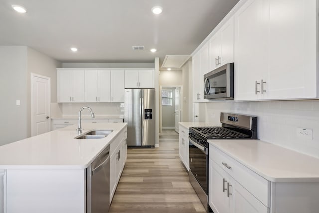 kitchen featuring white cabinetry, an island with sink, stainless steel appliances, and sink