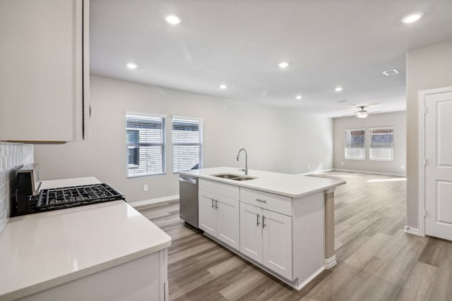 kitchen featuring white cabinetry, sink, stainless steel dishwasher, and an island with sink