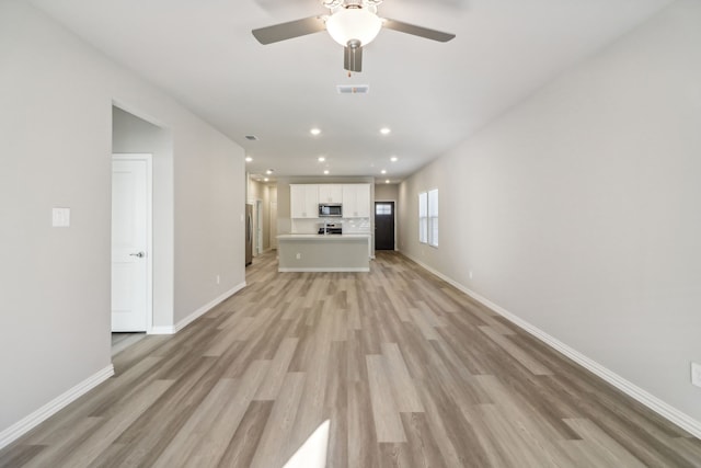 unfurnished living room featuring ceiling fan and light wood-type flooring