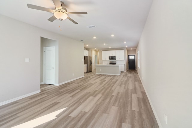 unfurnished living room featuring ceiling fan and light wood-type flooring