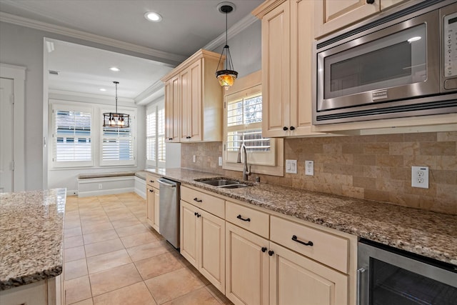 kitchen with appliances with stainless steel finishes, decorative light fixtures, sink, wine cooler, and light stone countertops