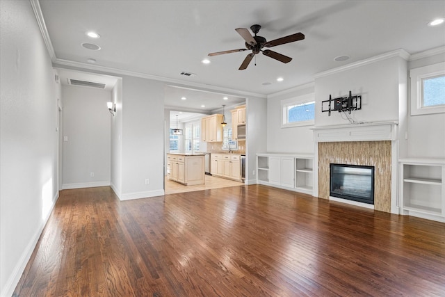 unfurnished living room with crown molding, ceiling fan, and hardwood / wood-style flooring