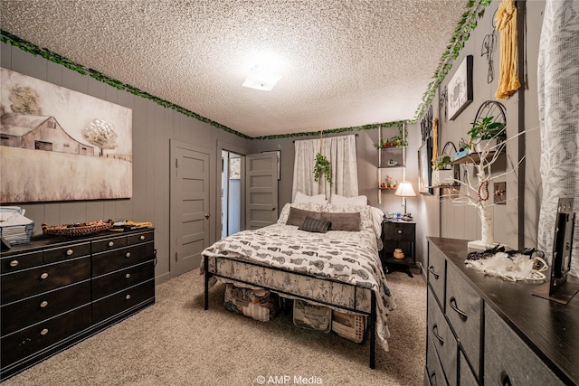 carpeted bedroom featuring wooden walls and a textured ceiling