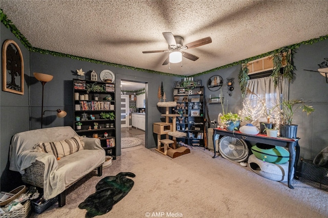 sitting room featuring ceiling fan, a textured ceiling, and carpet flooring