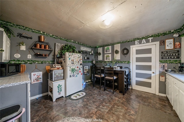 kitchen with white refrigerator and white cabinets