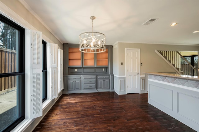 kitchen featuring decorative light fixtures, gray cabinetry, dark hardwood / wood-style flooring, crown molding, and an inviting chandelier