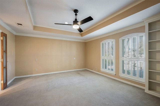 carpeted spare room with a raised ceiling, crown molding, and ceiling fan