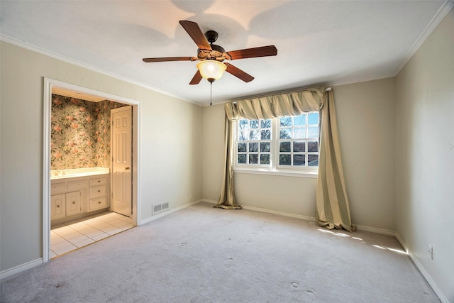 unfurnished bedroom with ceiling fan, ornamental molding, ensuite bathroom, and light carpet