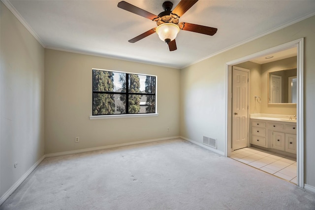 unfurnished bedroom with ensuite bathroom, sink, light carpet, ornamental molding, and ceiling fan