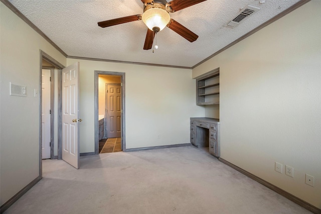 unfurnished living room featuring ceiling fan, light colored carpet, ornamental molding, and a textured ceiling