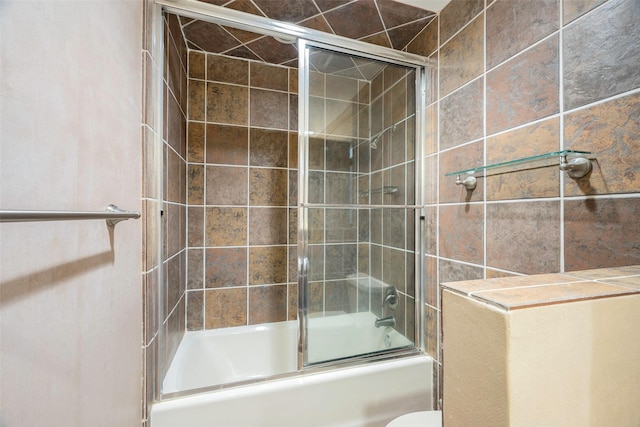 bathroom featuring shower / bath combination with glass door and toilet