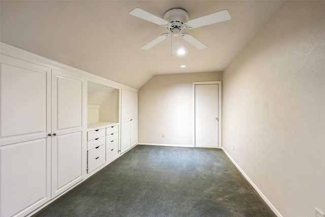 additional living space featuring ceiling fan, lofted ceiling, and dark carpet