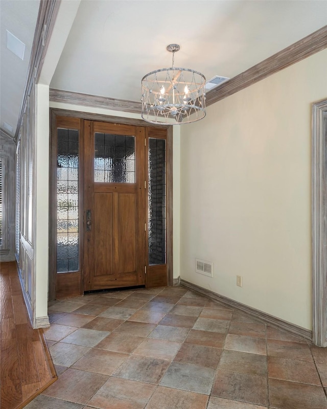 foyer entrance with crown molding, plenty of natural light, and a chandelier